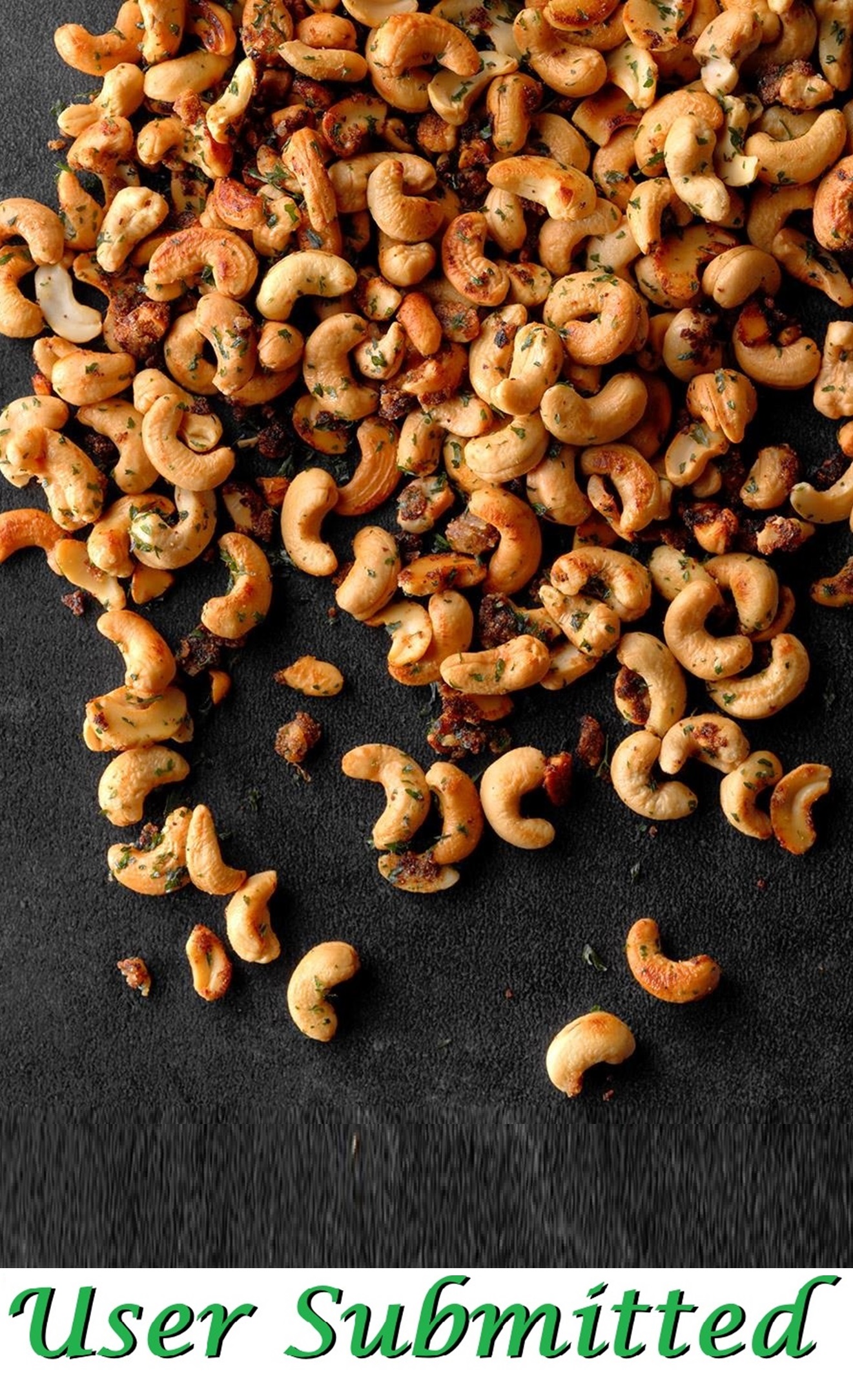Garlic-and-onion seasoned cashews cooling on parchment.