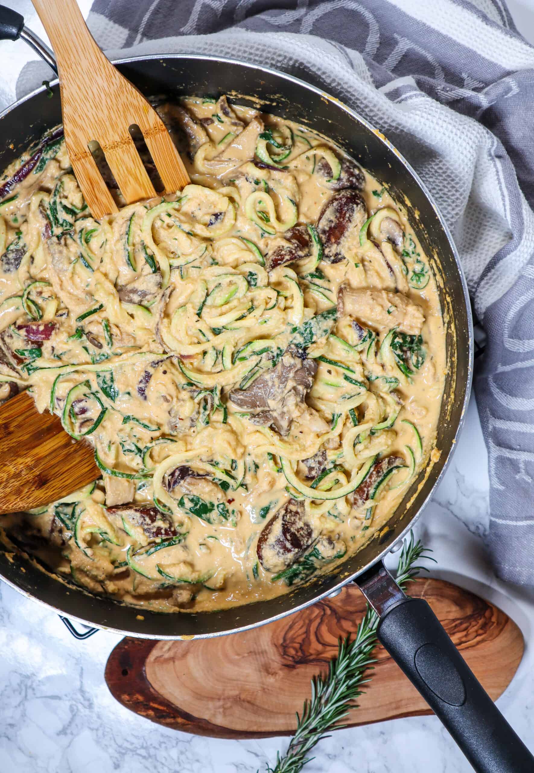 Creamy cashew-based pasta sauce coating noodles in a skillet.